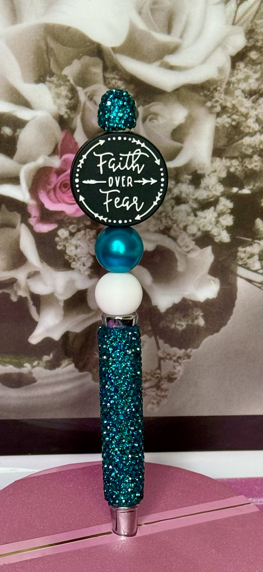 Decorative pen with 'Faith Over Fear' quote against a floral background