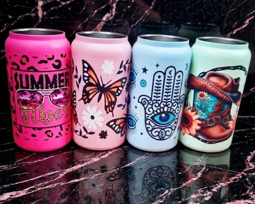 Four colorful cans with artistic designs on a marble surface